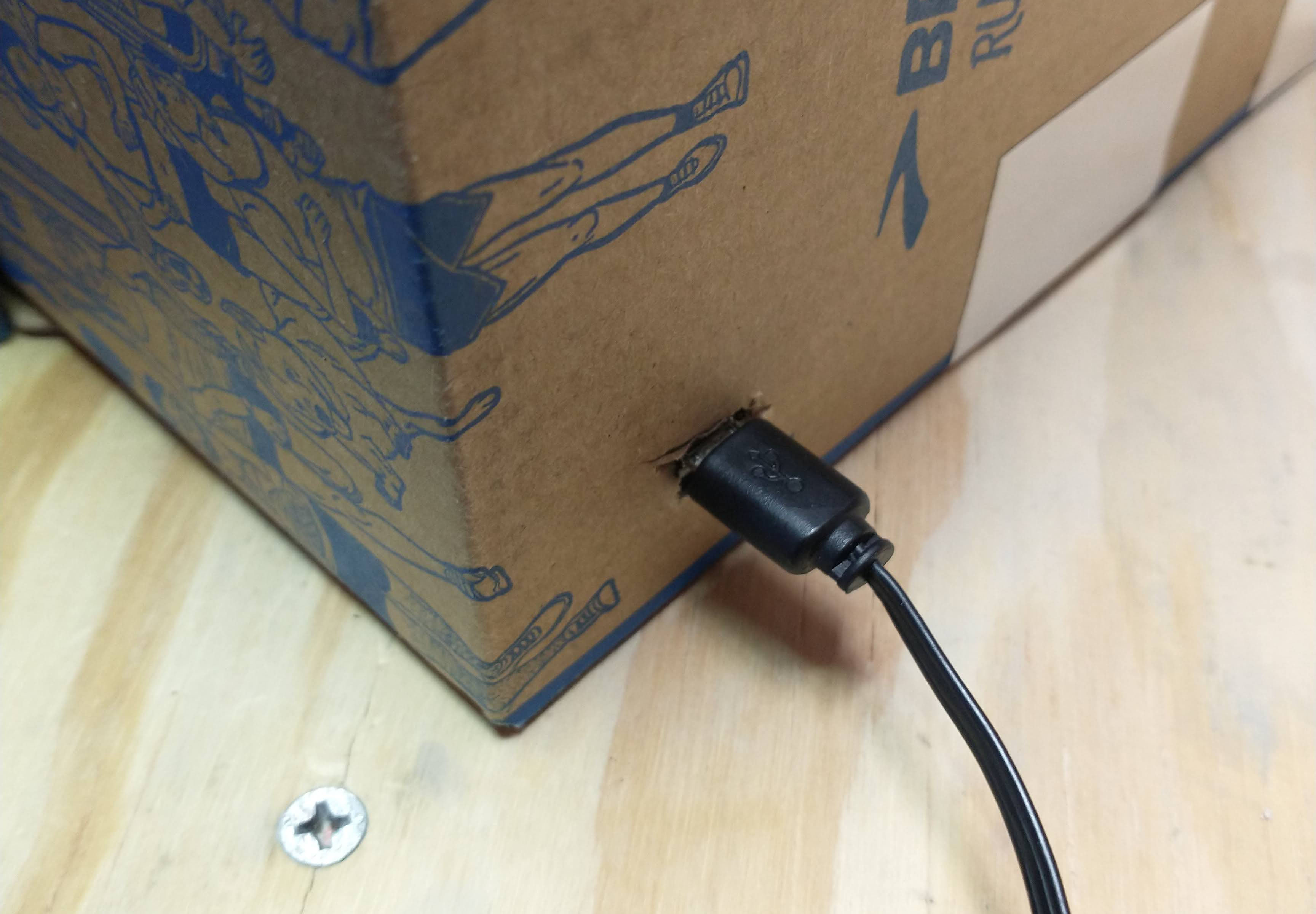 A picture of the back of the box with a small cut in which a micro USB is attached